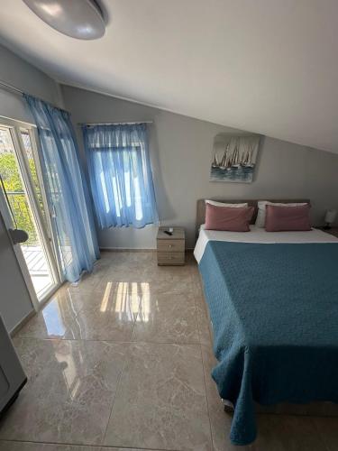 a bedroom with a bed with blue sheets and pink pillows at F&R Villa - Family Apartment No6 - 2 bedrooms in Perea