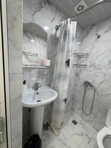 a white bathroom with a sink and a shower at Sun House in Yeghegnadzor