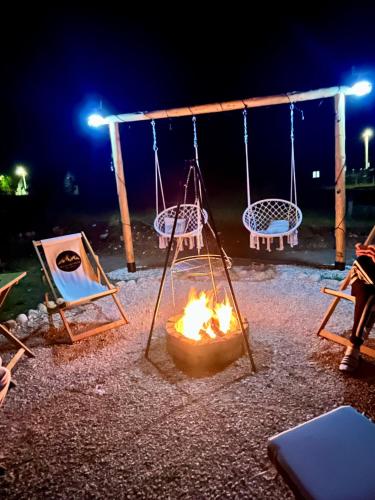 a fire pit with a swing and a fire at Cottage Sanja in Žabljak
