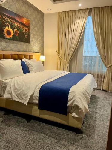 a bedroom with a large bed and a window at نزل فلل الريف alreef villas in Baljurashi
