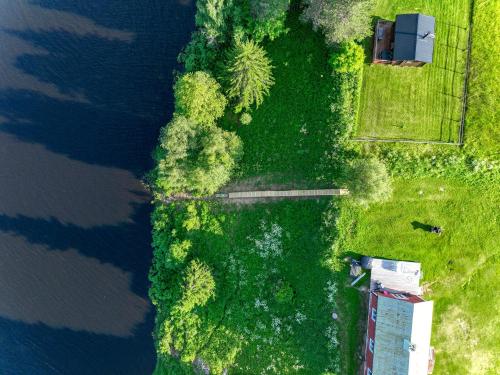 an aerial view of a field with trees and water at SBC Guest House in Pajala
