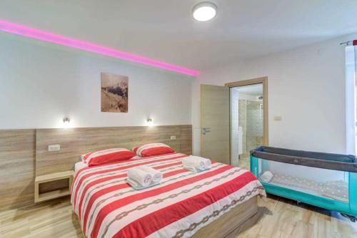 a bedroom with a large bed with red and white sheets at Villa Milla by aneo travel in Novi Vinodolski