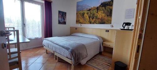 a small bedroom with a bed and a window at Bed & breakfast Villa Maria in Cavalese