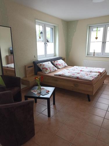 a bedroom with a large bed and a table at Ferienwohnung Hermann in Sankt Aldegund