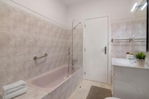 a bathroom with a tub and a sink and a shower at Refúgio Estrela do Mar in Quarteira