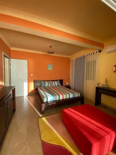 a bedroom with two beds and an orange wall at Villa Sahitia Marine in Mahajanga