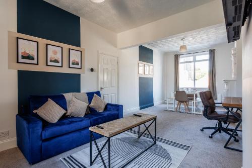 a living room with a blue couch and a table at The Mowbray Hub Relax, Work, Explore in Stockton-on-Tees