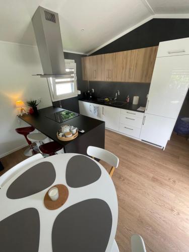 a kitchen with a black and white table and chairs at Premium Chalet A in Ebenzweier