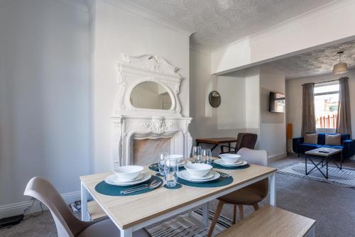 a dining room with a table and a fireplace at The Mowbray Hub Relax, Work, Explore in Stockton-on-Tees