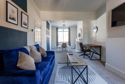 a living room with a blue couch and a table at The Mowbray Hub Relax, Work, Explore in Stockton-on-Tees