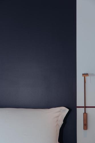 a bedroom with a white bed and a blue wall at Altoledo Rooms and Suite in Naples