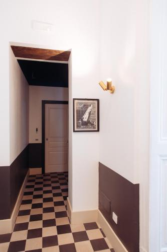 a hallway with a door and a checkered floor at Altoledo Rooms and Suite in Naples