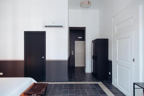 a bedroom with black doors and a black tile floor at Altoledo Rooms and Suite in Naples