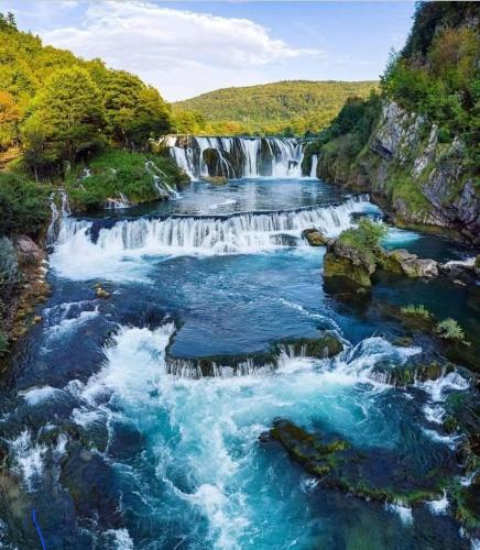 a waterfall in the middle of a river at Apartment Beha in Bihać