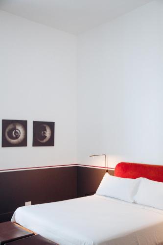 a bedroom with a white bed and two pictures on the wall at Altoledo Rooms and Suite in Naples