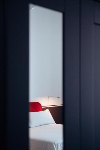 a bedroom with a bed with a red headboard and white sheets at Altoledo Rooms and Suite in Naples