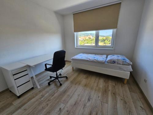 a bedroom with a desk and a bed and a chair at Soblahov apartment in Soblahov