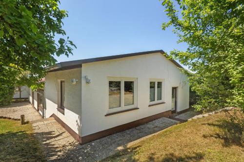 a small white house with trees in front of it at db staycation ferienpark in Niedenstein