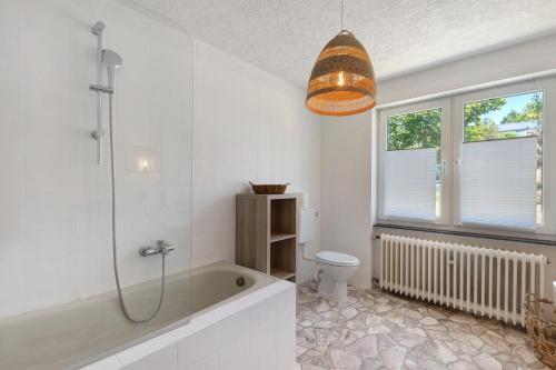 a bathroom with a bath tub and a toilet at db staycation ferienpark in Niedenstein
