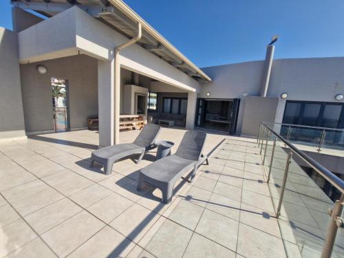 a patio with two chairs and stairs on a building at Whale Rock in Margate