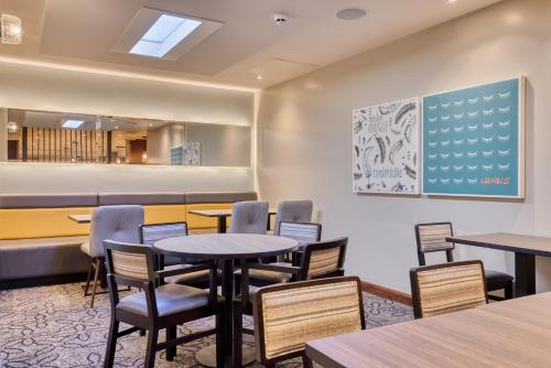 a waiting room with tables and chairs in a restaurant at Premier Inn Dublin City Temple Bar in Dublin