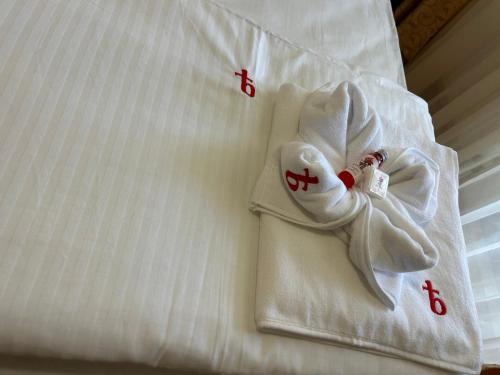 a white towel on a bed with red crosses on it at Park Hotel Panorama in Tryavna