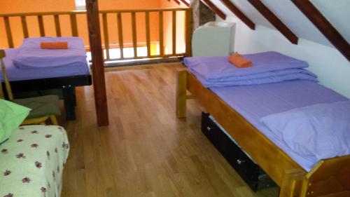 two beds in a room with a wooden floor at Holiday Home Baracka in Bezdan