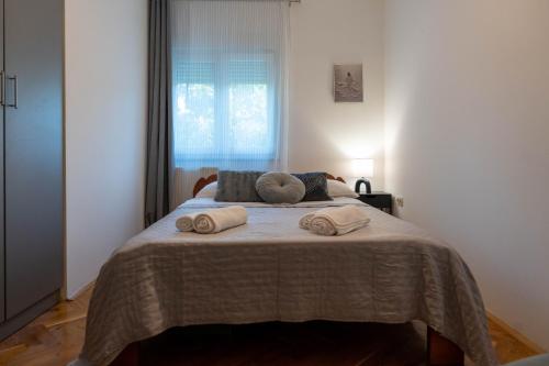 a bedroom with a bed with two towels on it at Holiday house with a swimming pool Zmijavci, Zagora - 24240 in Zmijavci