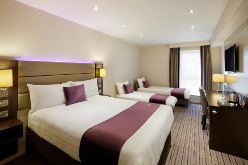 a hotel room with two beds and a television at Premier Inn Dublin City Temple Bar in Dublin