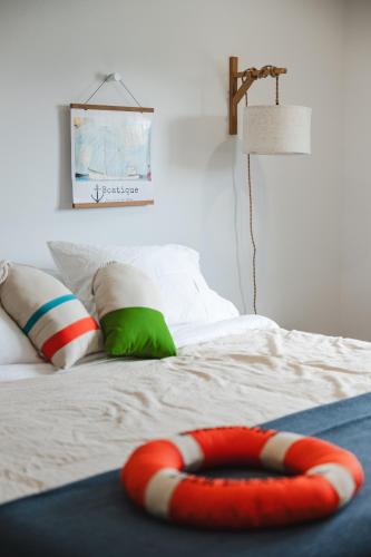 a bed with a red and white object on it at Homeport Suites & Residences in Lords Cove 