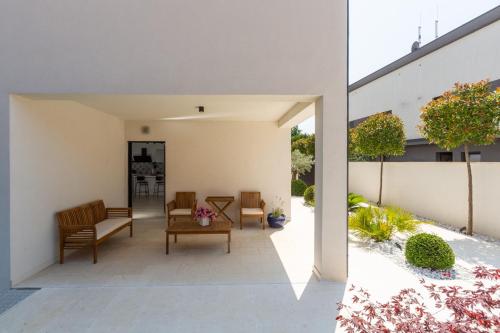 an internal courtyard of a house with chairs and a table at Villa Ventana with terrace and BBQ in Savudrija