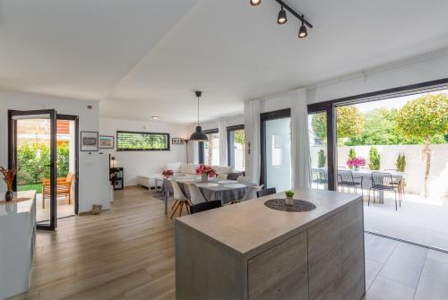 a kitchen and living room with a table and chairs at Villa Ventana with terrace and BBQ in Savudrija