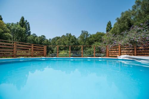 une grande piscine avec une clôture en bois dans l'établissement Maison avec piscine chauffée, à Kervignac
