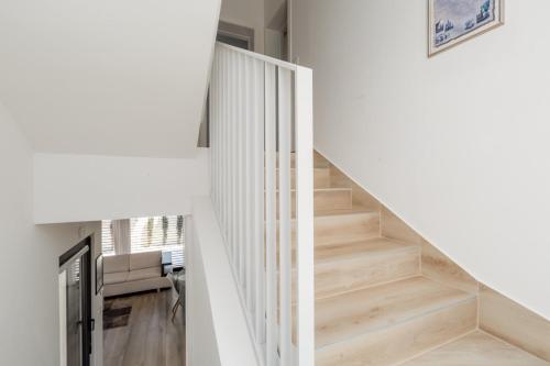 a staircase in a house with white walls and wooden floors at Villa Ventana with terrace and BBQ in Savudrija