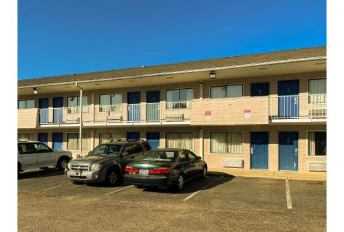 two cars parked in a parking lot in front of a building at Motel 6 Millington TN in Millington