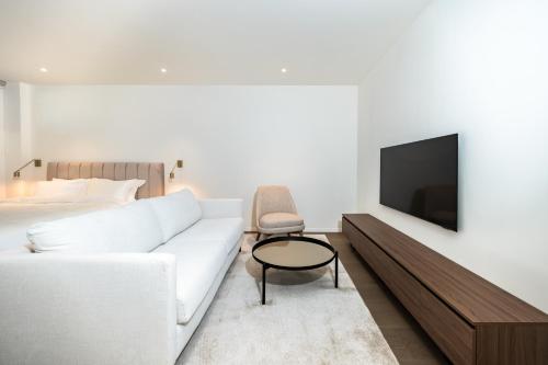 a living room with a white couch and a tv at Petram Resort & Residences in Savudrija