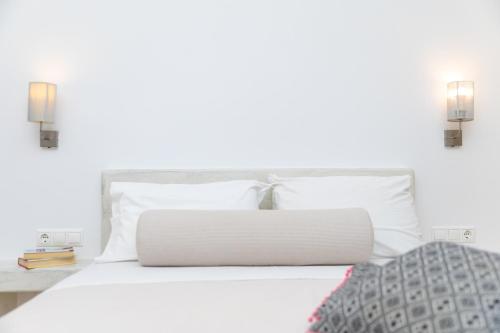 a bedroom with a white bed with white pillows at Depis place & apartments naxos in Naxos Chora