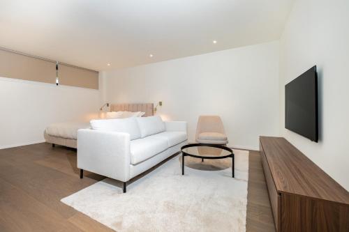 a living room with a white couch and a bed at Petram Resort & Residences in Savudrija