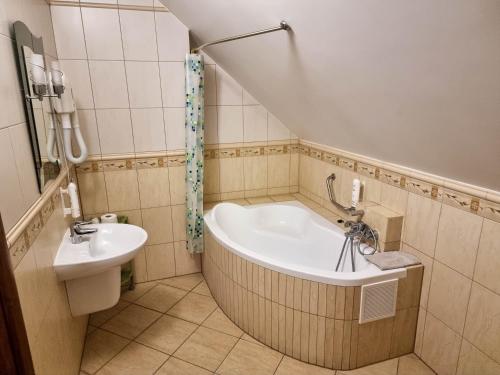 a bathroom with a bath tub and a sink at Hotel Hesperus in Międzyrzec Podlaski