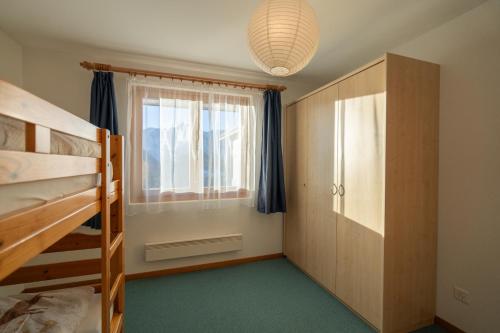 a bedroom with two bunk beds and a window at Chalet Capricorn in Bettmeralp