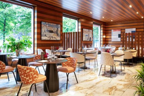 a restaurant with tables and chairs and windows at Hotel Meliá Bilbao in Bilbao