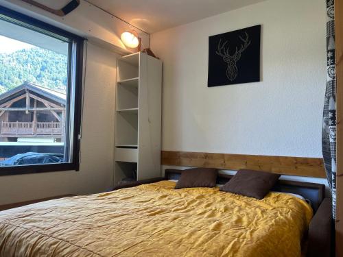 une chambre avec un lit et une grande fenêtre dans l'établissement Chaleureux studio centre Samoëns, balcon, proche commodités et skibus - FR-1-624-83, à Samoëns