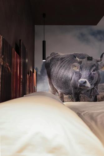 a statue of a cow standing next to a building at Crimea Wine Hotel in Chiavenna