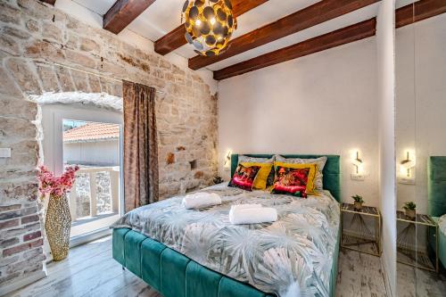 una camera da letto con un letto grande con cuscini colorati di Luxury Villa Unikat with Seaview & Jacuzzi a Milna