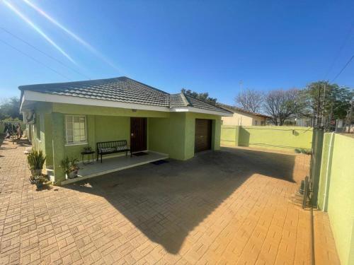 a small green house with a patio in front of it at Innovative Hospitality in Gaborone