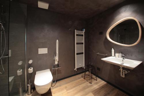 a bathroom with a sink and a toilet and a mirror at Crimea Wine Hotel in Chiavenna