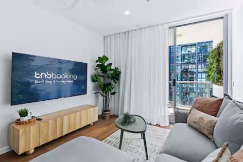a living room with a couch and a large window at Elevate Brisbane City - Views, Pool, Sauna & Gym in Brisbane