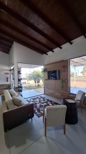 a living room with a couch and a tv at Pousada Muller in Paraíso do Sul