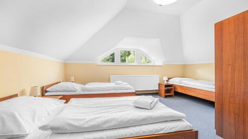 a bedroom with two beds and a window at Hotel Samechov - konferenční hotel in Samechov