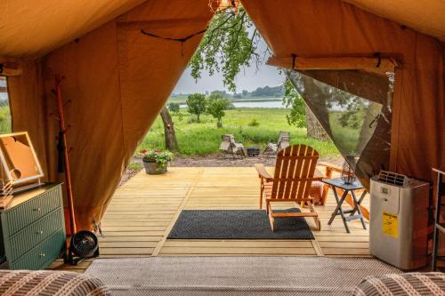 a tent with a deck with a chair and a table at Painted Prairie - Prairie Hause in Currie